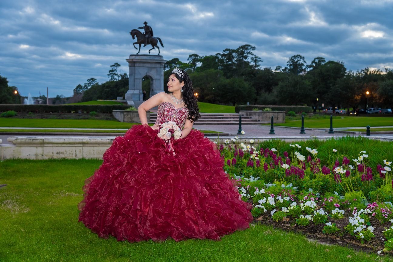 Young woman in red gown in a park
