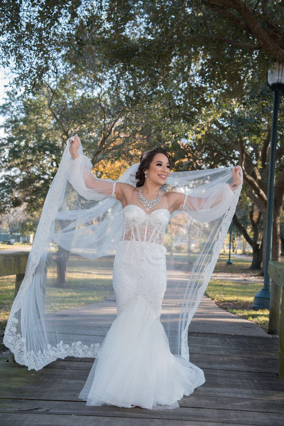Bride showing off wedding dress with flowing veil
