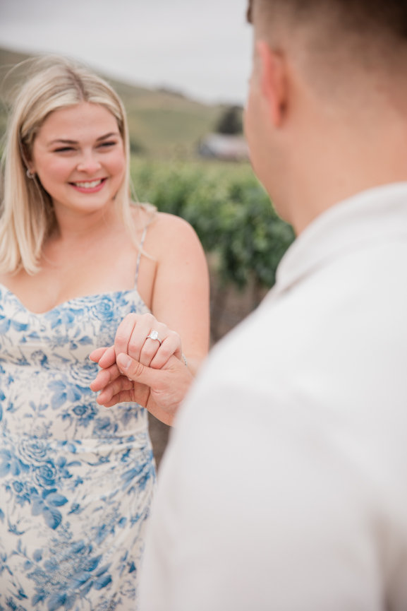 Man and woman holding hands after proposal at Roche Winery in Sonoma California,