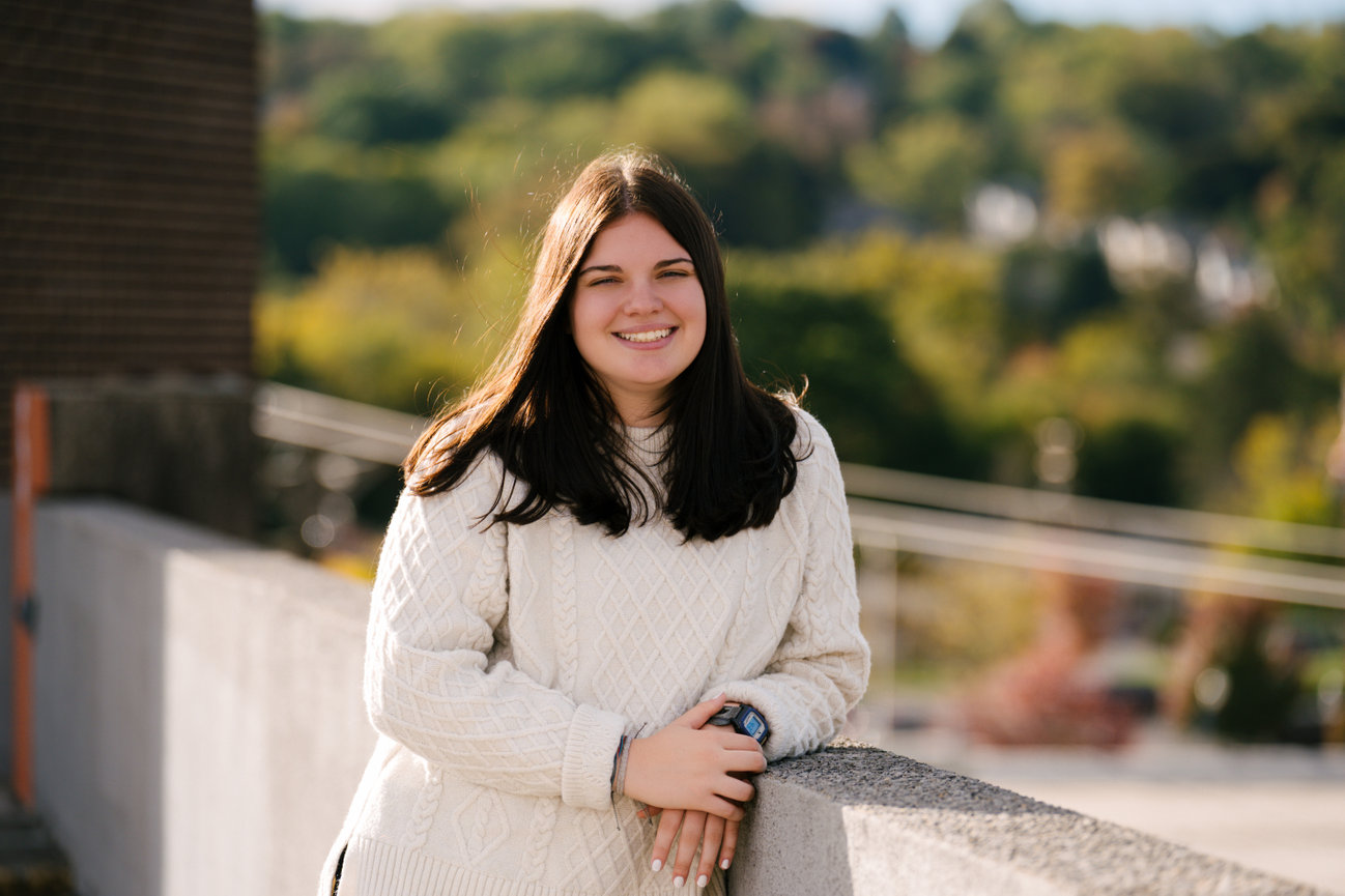 senior girl pictures on a parking garage rooftop in sharon pa wearing a casual sweater and jeans outfit