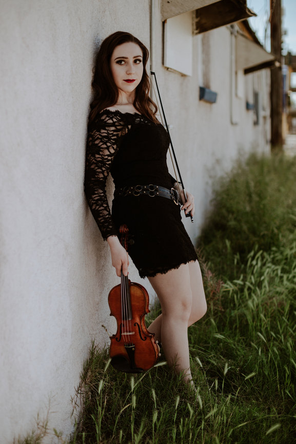 Professional portrait of violinist in downtown Las Vegas wearing short black dress and red lipstick. Professional picture taken by Adam Trujillo, a Las Vegas studio portrait photographer.