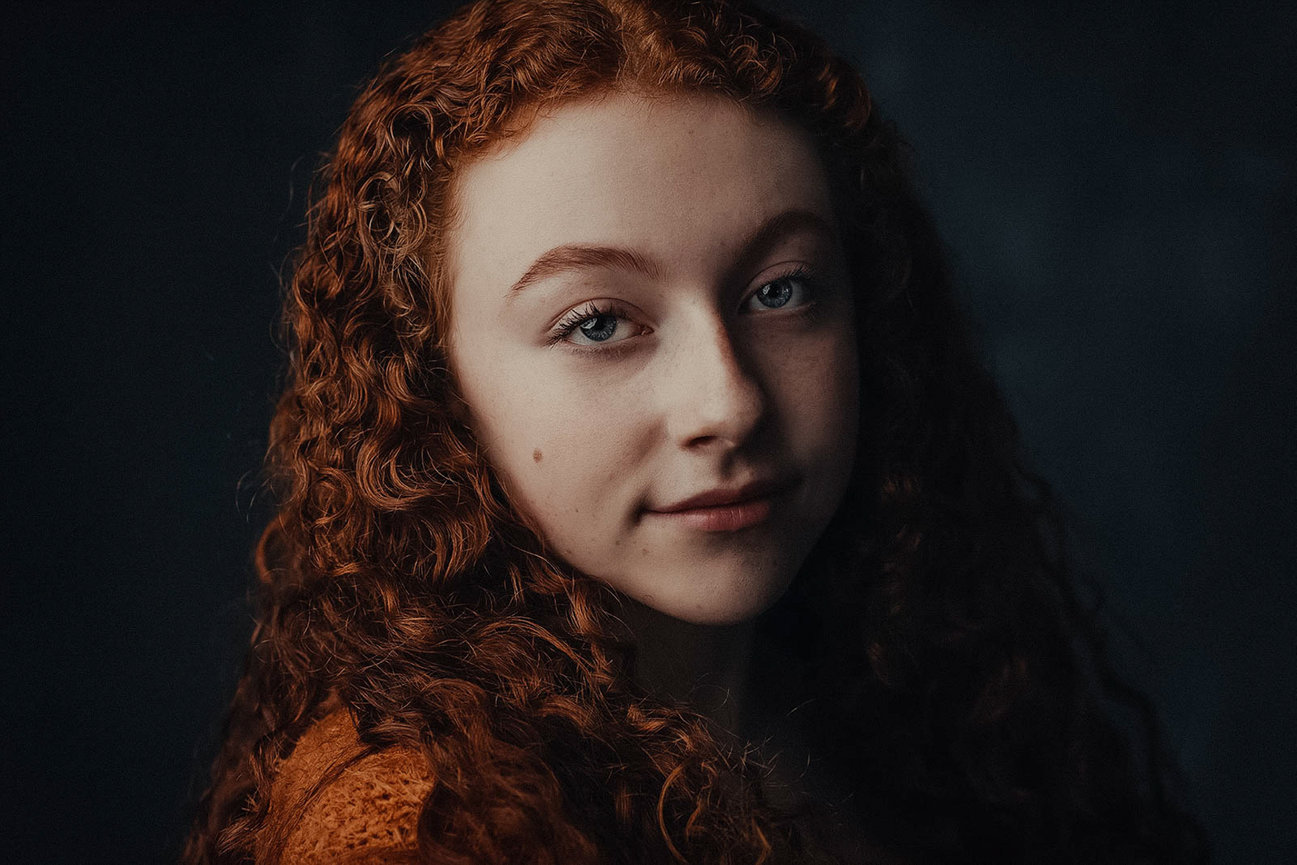 High-end Las Vegas professional photography and studio portraits by Adam Trujillo, styled with creative lighting and beauty services. Check out the lovely curly red hair in this stunning portrait.