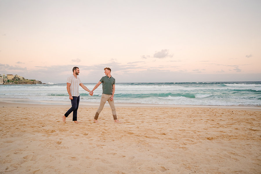 Couple walking on the beach in a Bondi Beach Vacation Photoshoot.