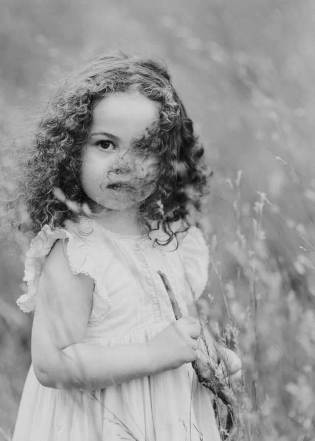 Black and White Image of a little girl in tall grass