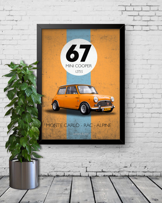 Framed poster of an orange Mini Cooper 67 rally car beside a potted plant on a white brick wall