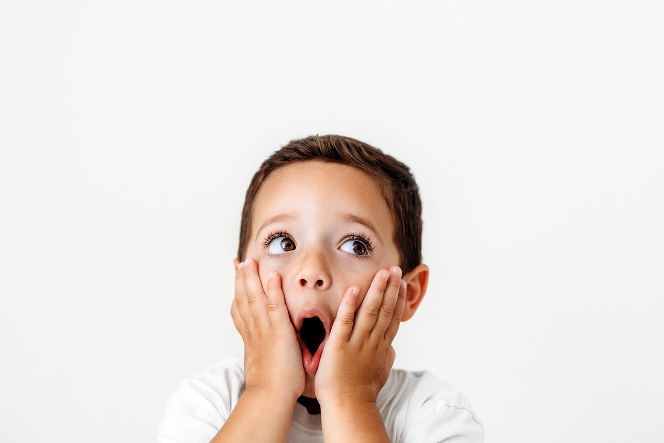 Child photographer Orange County expressive toddler portrait with playful facial expression