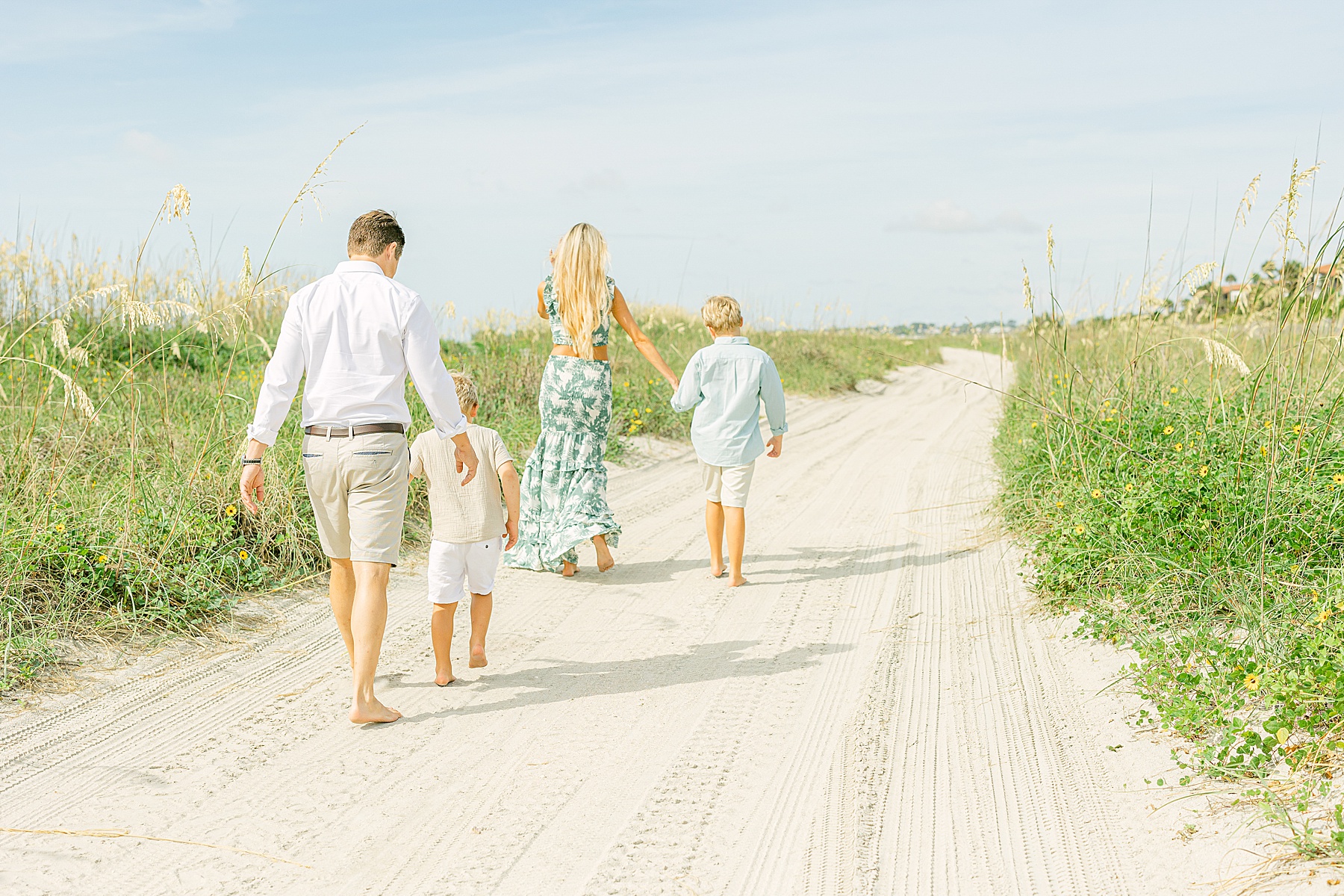 family walking on beach middle of the day wearing neutral colors