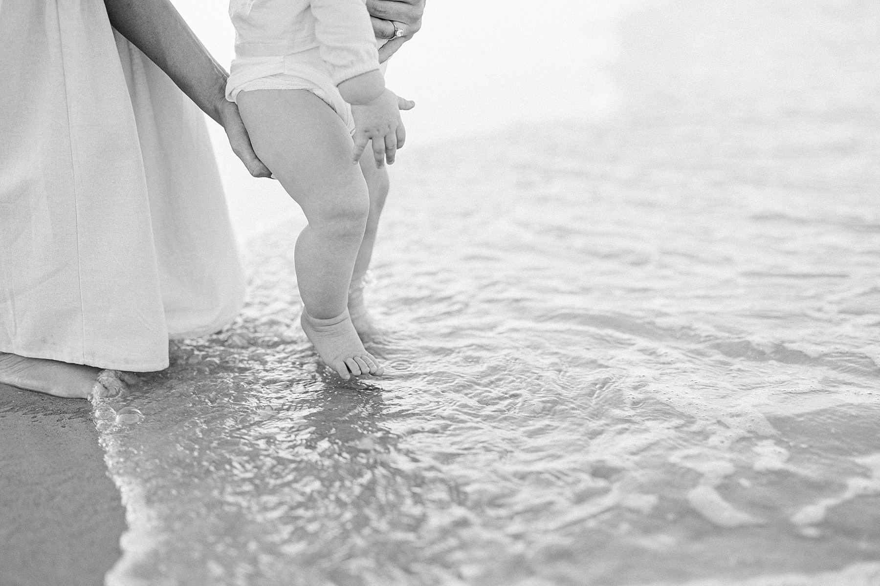 baby toes in the water in black and white image