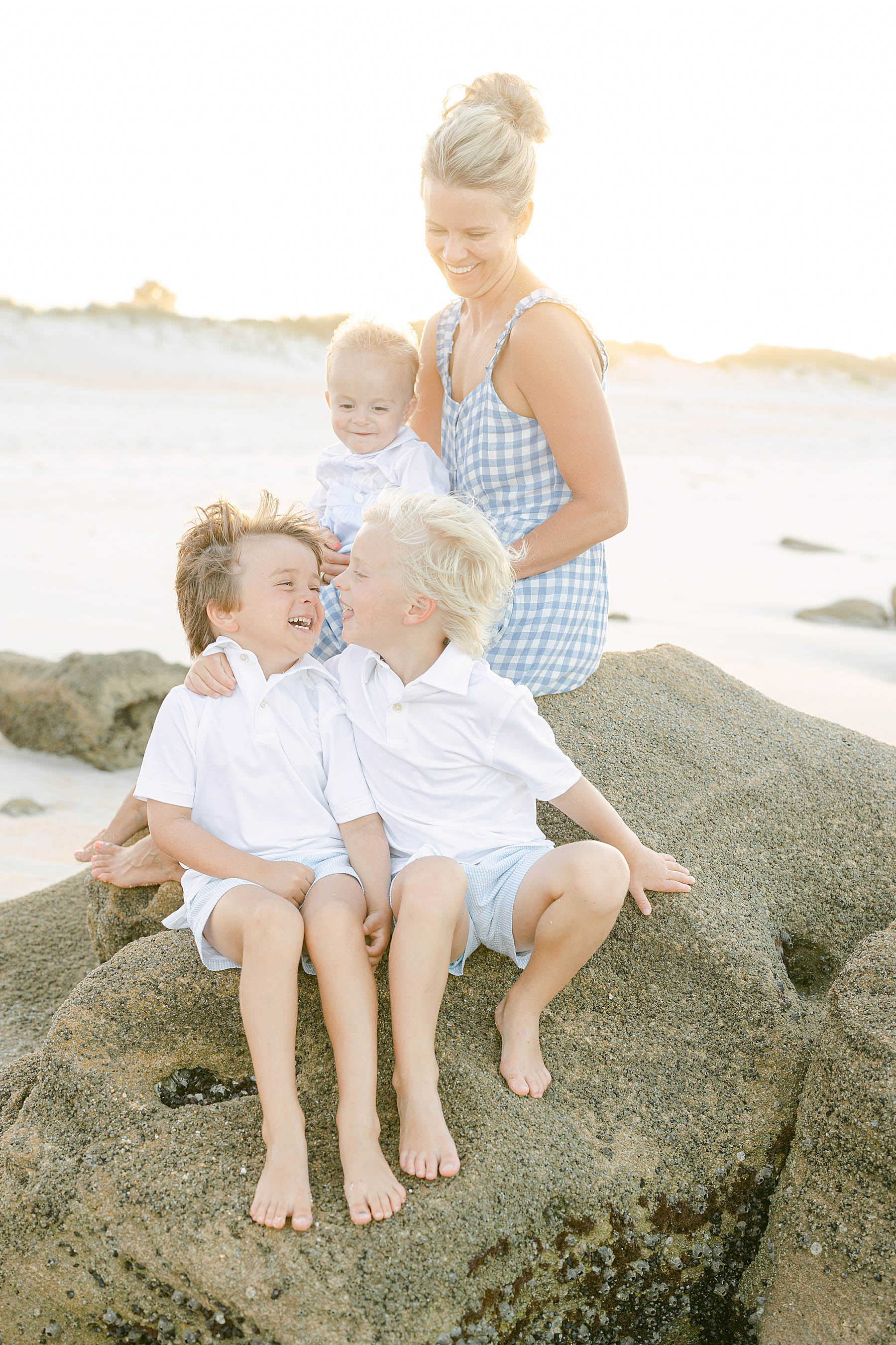mom with her children on the beach at sunset wearing white