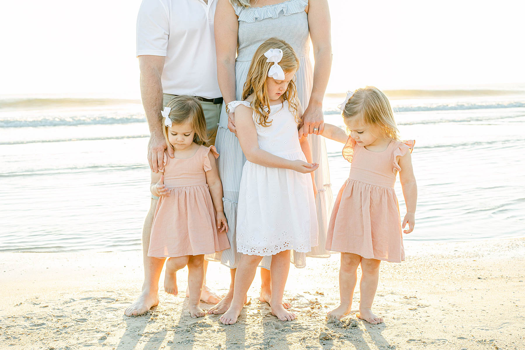 family walking on the beach at sunrise