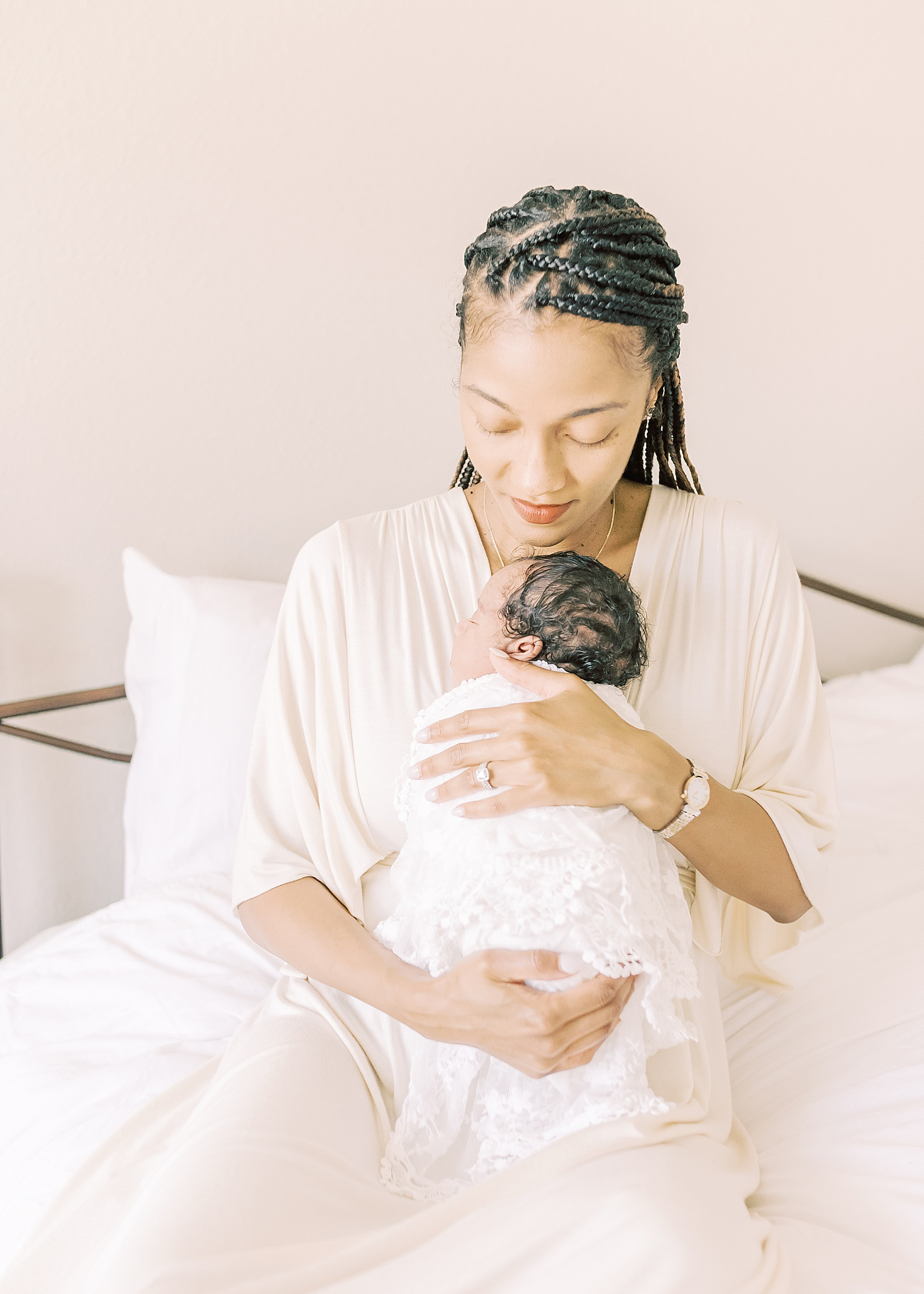 man and woman holding a baby girl on a white bed