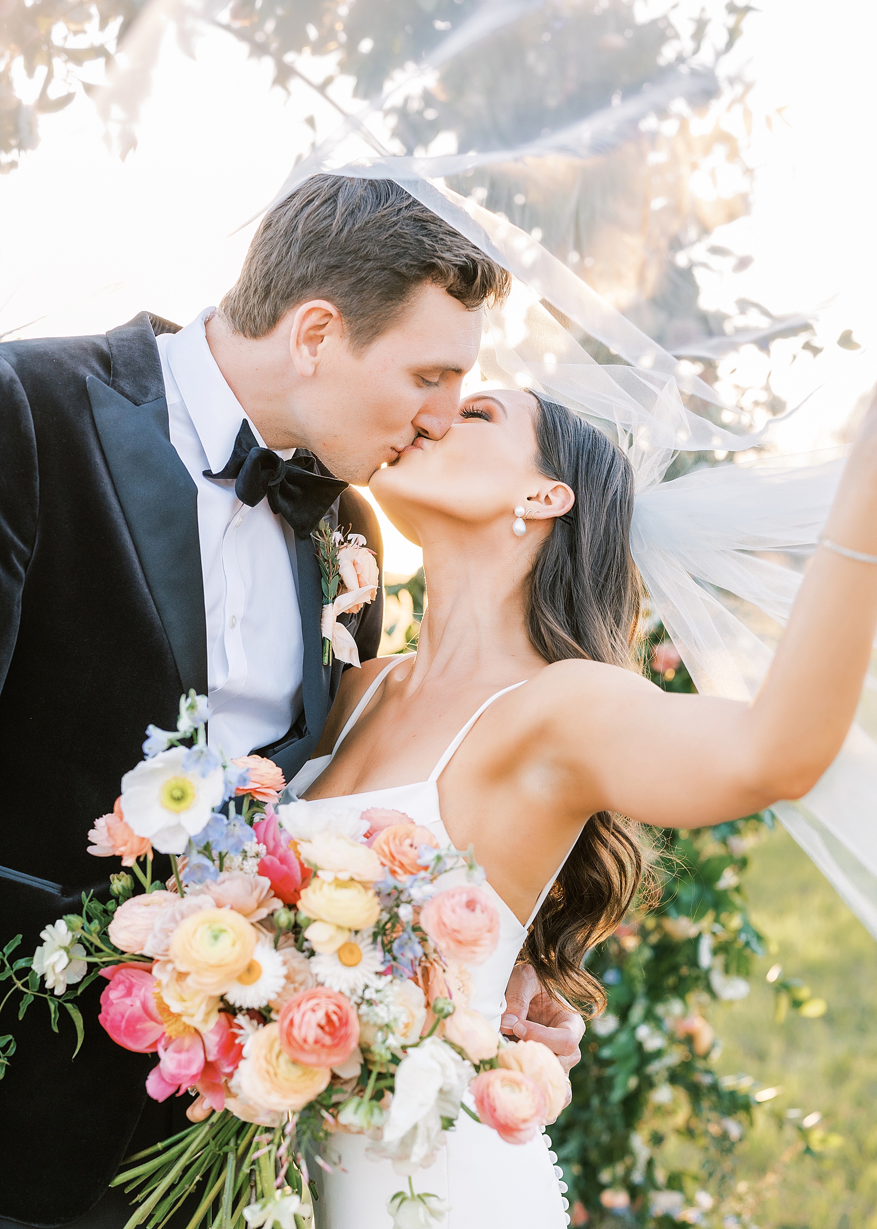 bride in white wedding dress under veil kissing groom in tuxedo on private estate in north florida