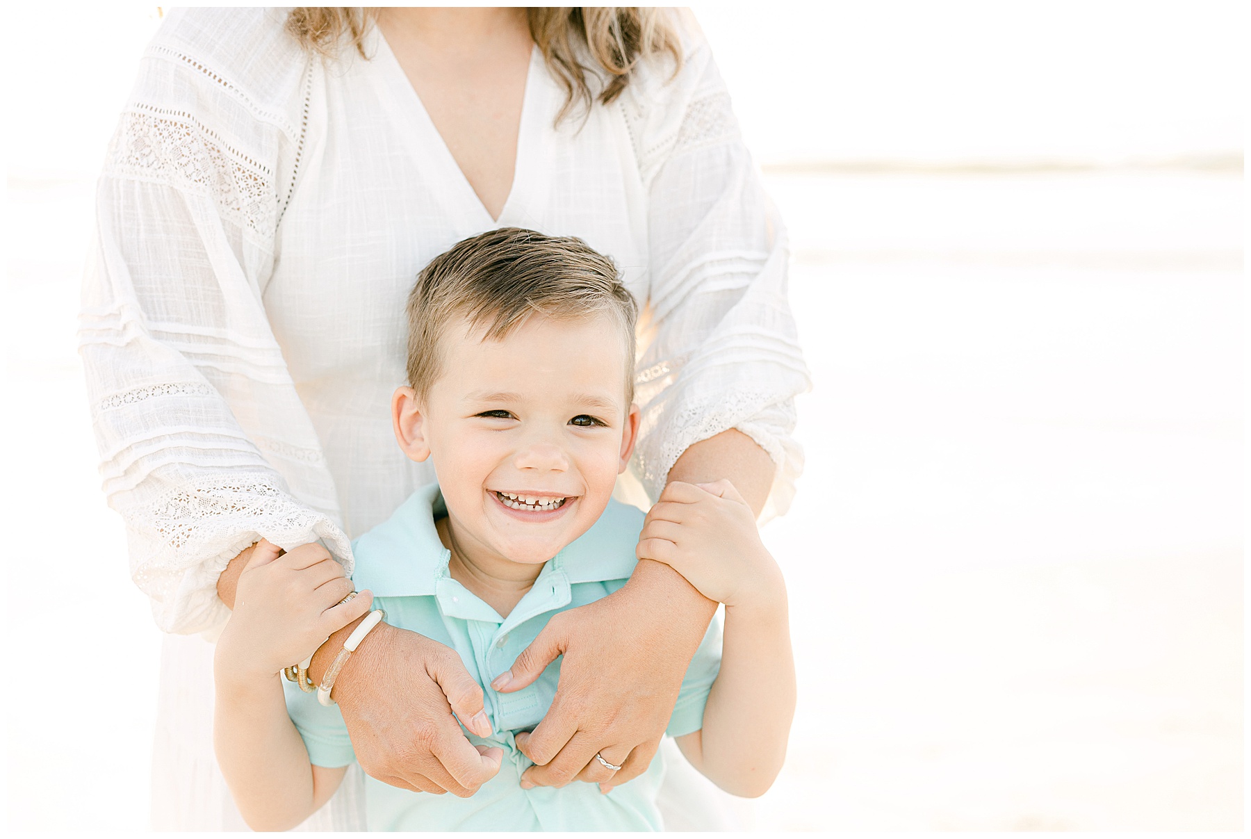 light and airy photo of little boy holding his mom on the beach at sunrise in saint augustine florida