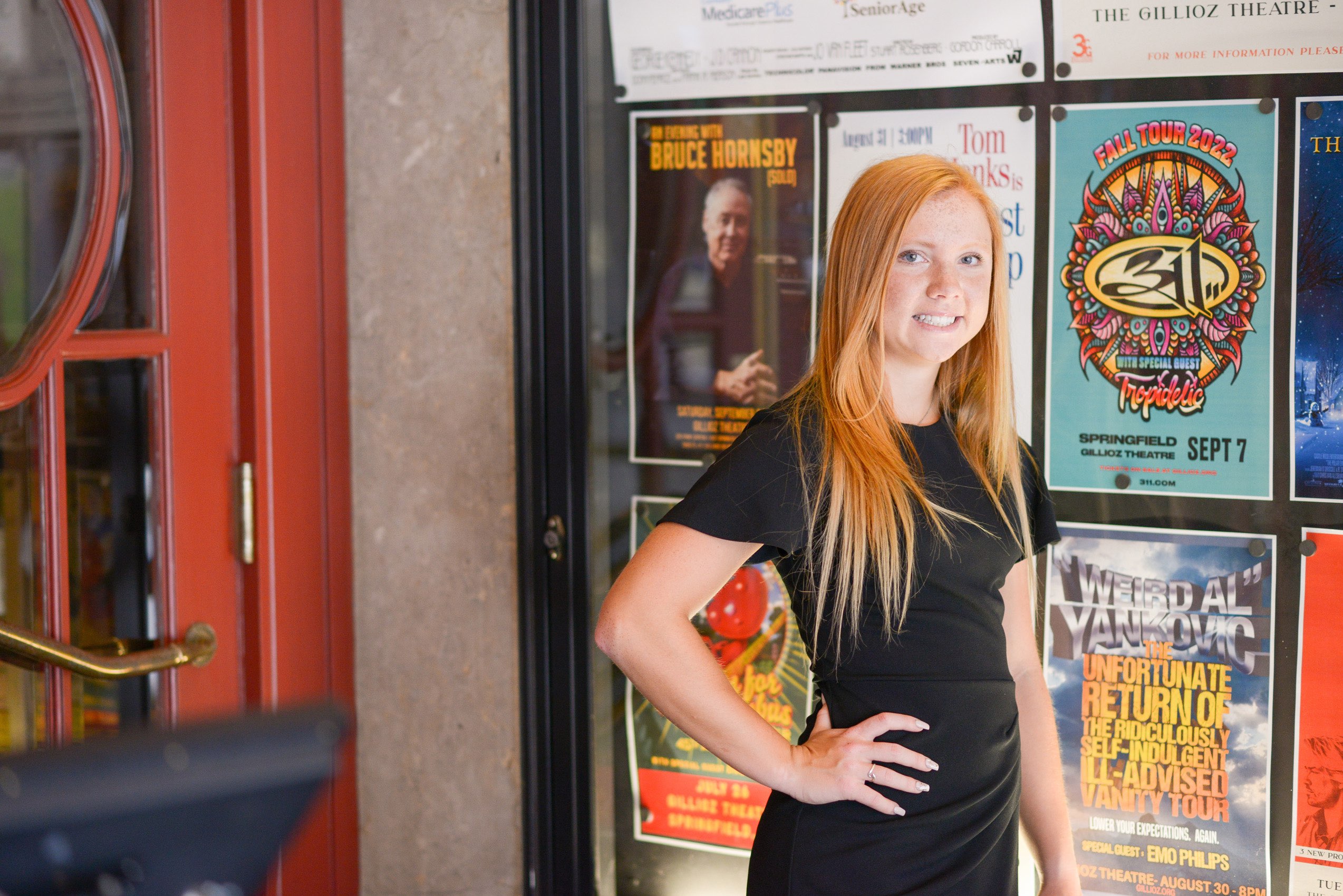 Senior portraits at the Gilloiz Theatre in front of colorful show posters.