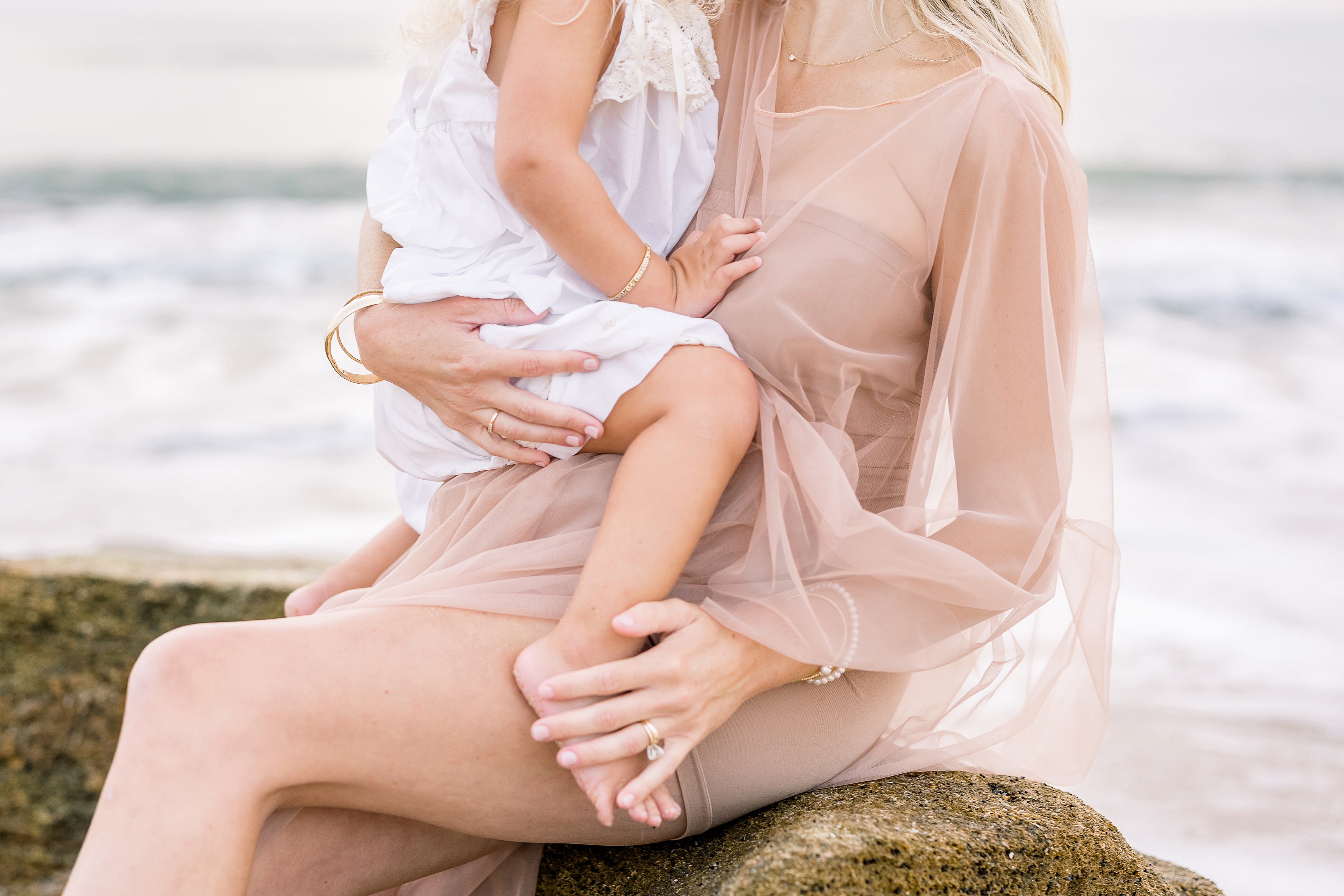 light and airy maternity photo of mother with daughter in white dress