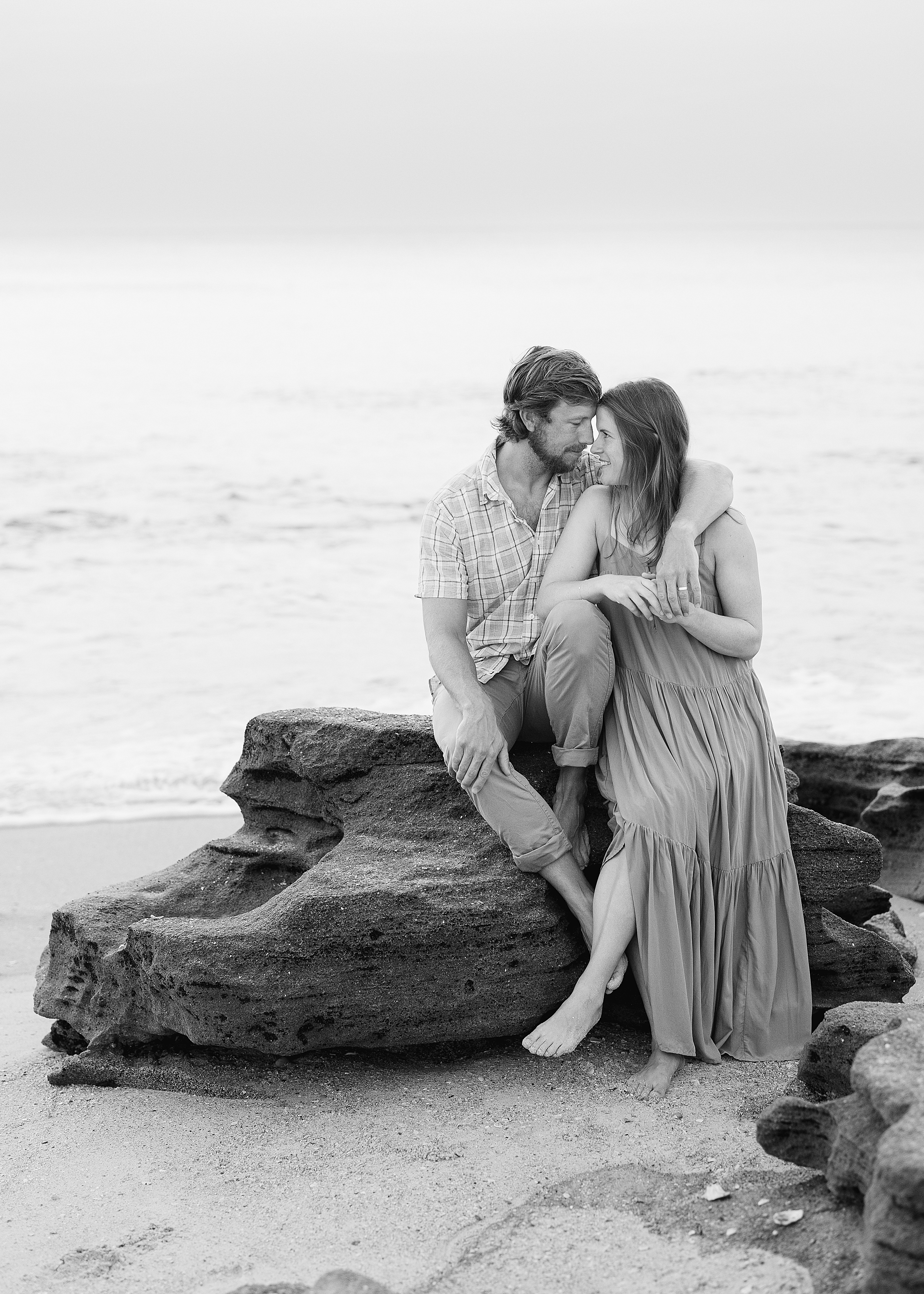 Black and white coastal portrait of man and woman in neutral colors.