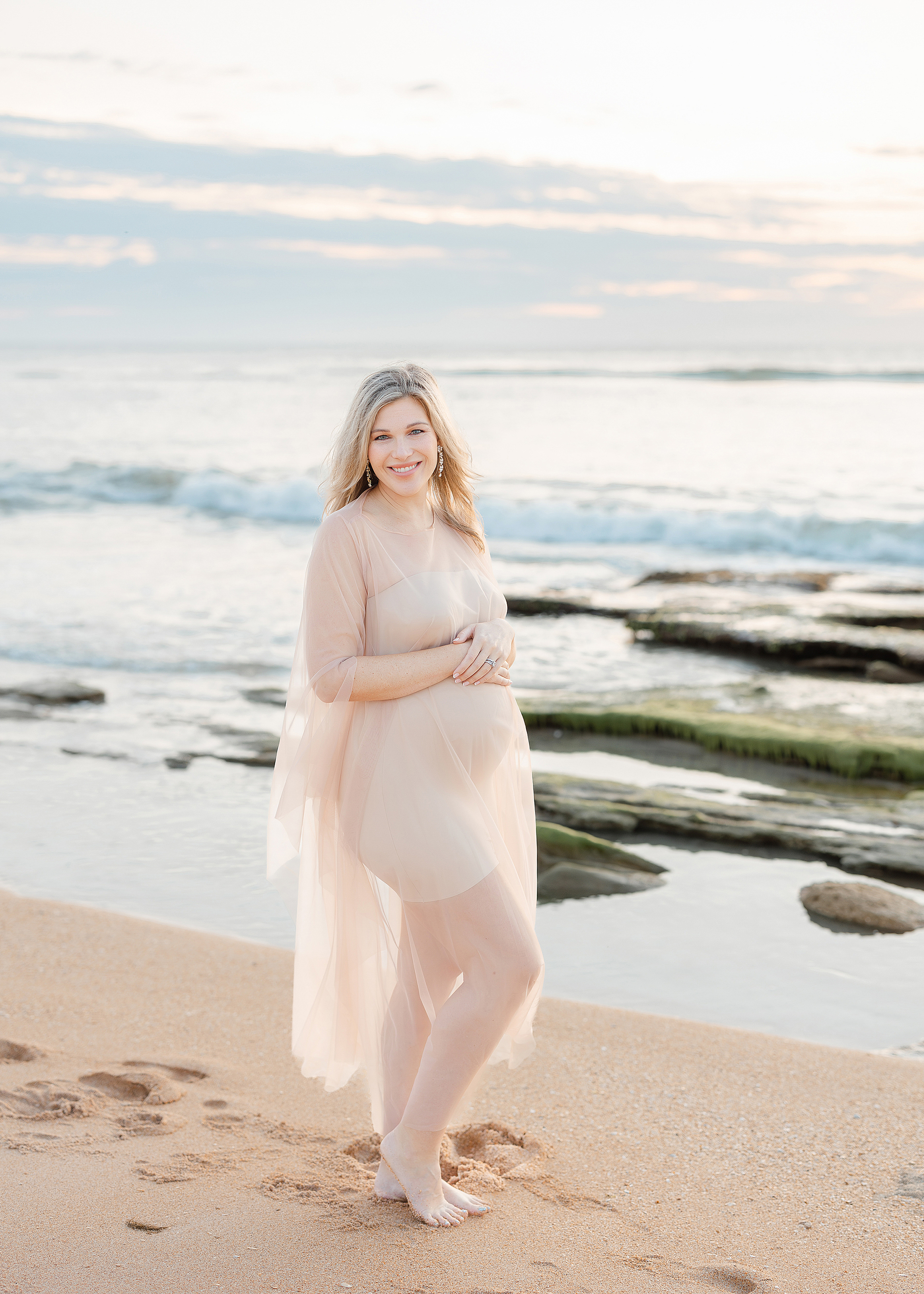 Sunrise maternity portrait of a woman on the shoreline in St. Augustine.