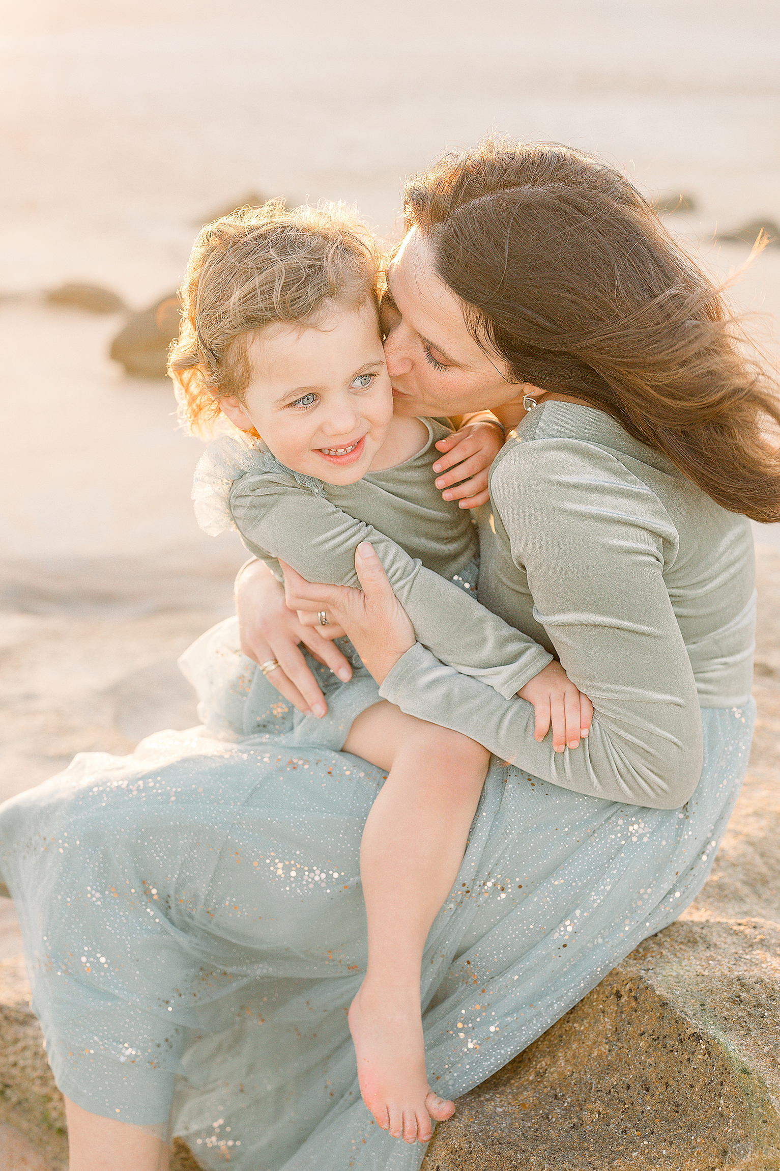 A pastel family beach portrait at sunset.