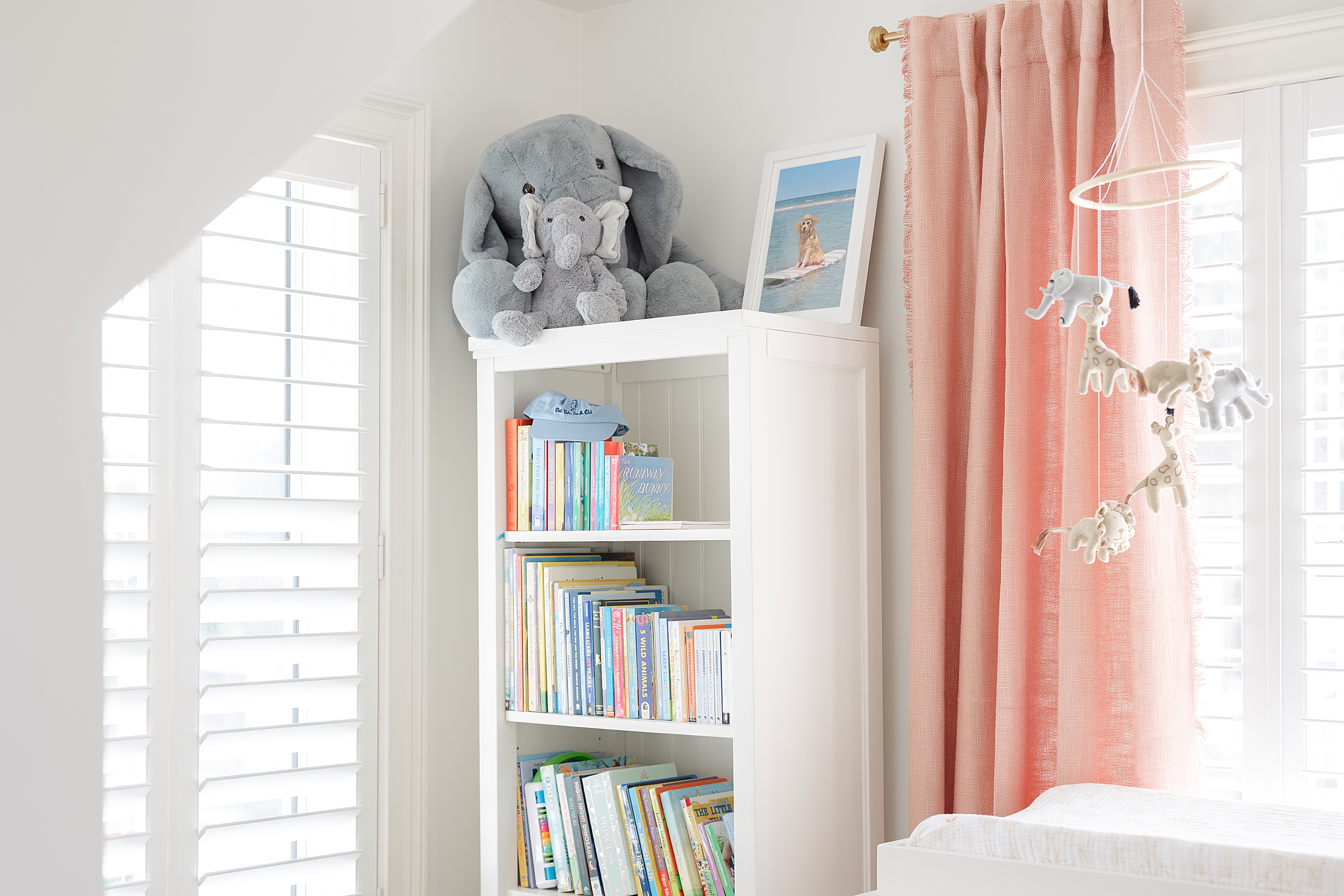 An interior designed baby girl's nursery showcasing whites and pinks.