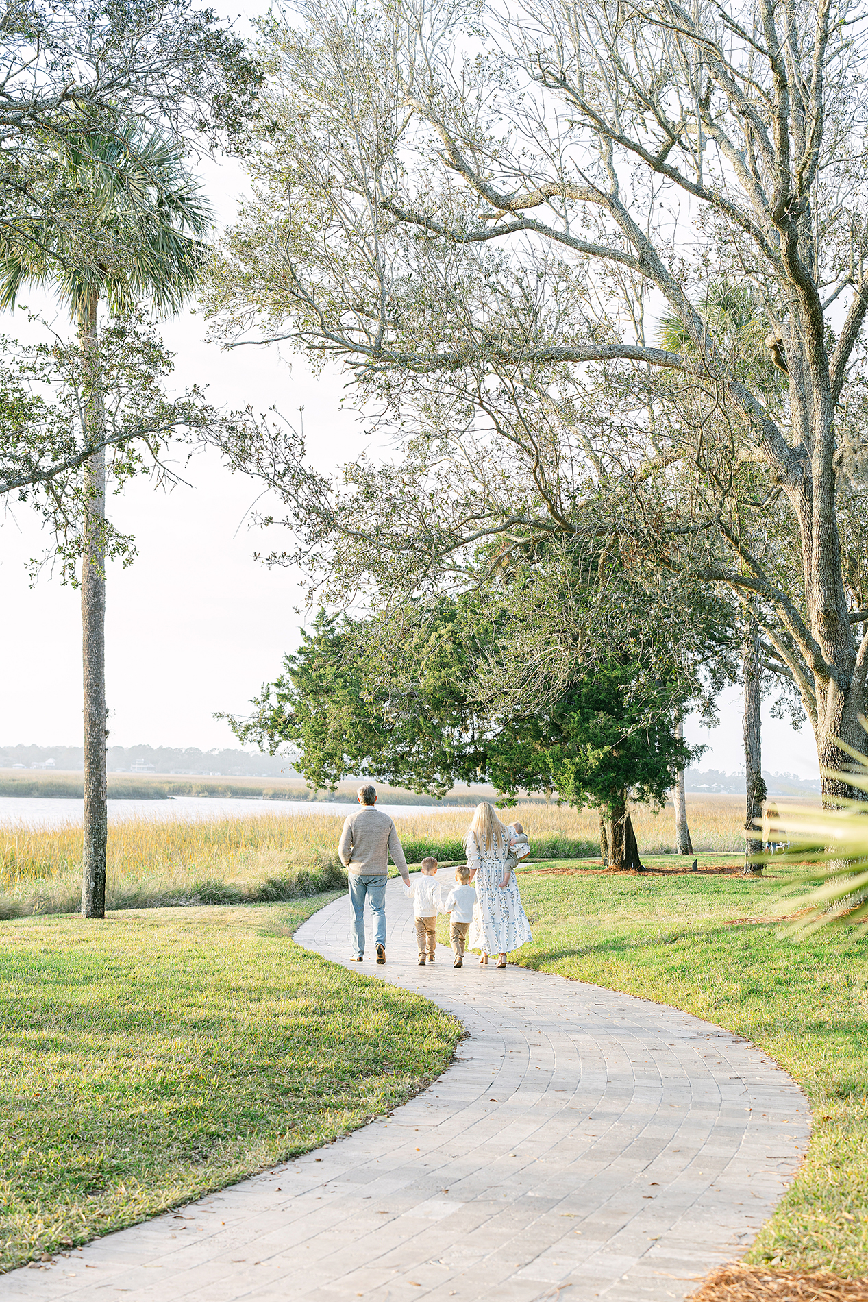 A candid lifestyle portrait of a family walking down the stone path of the Cloister.