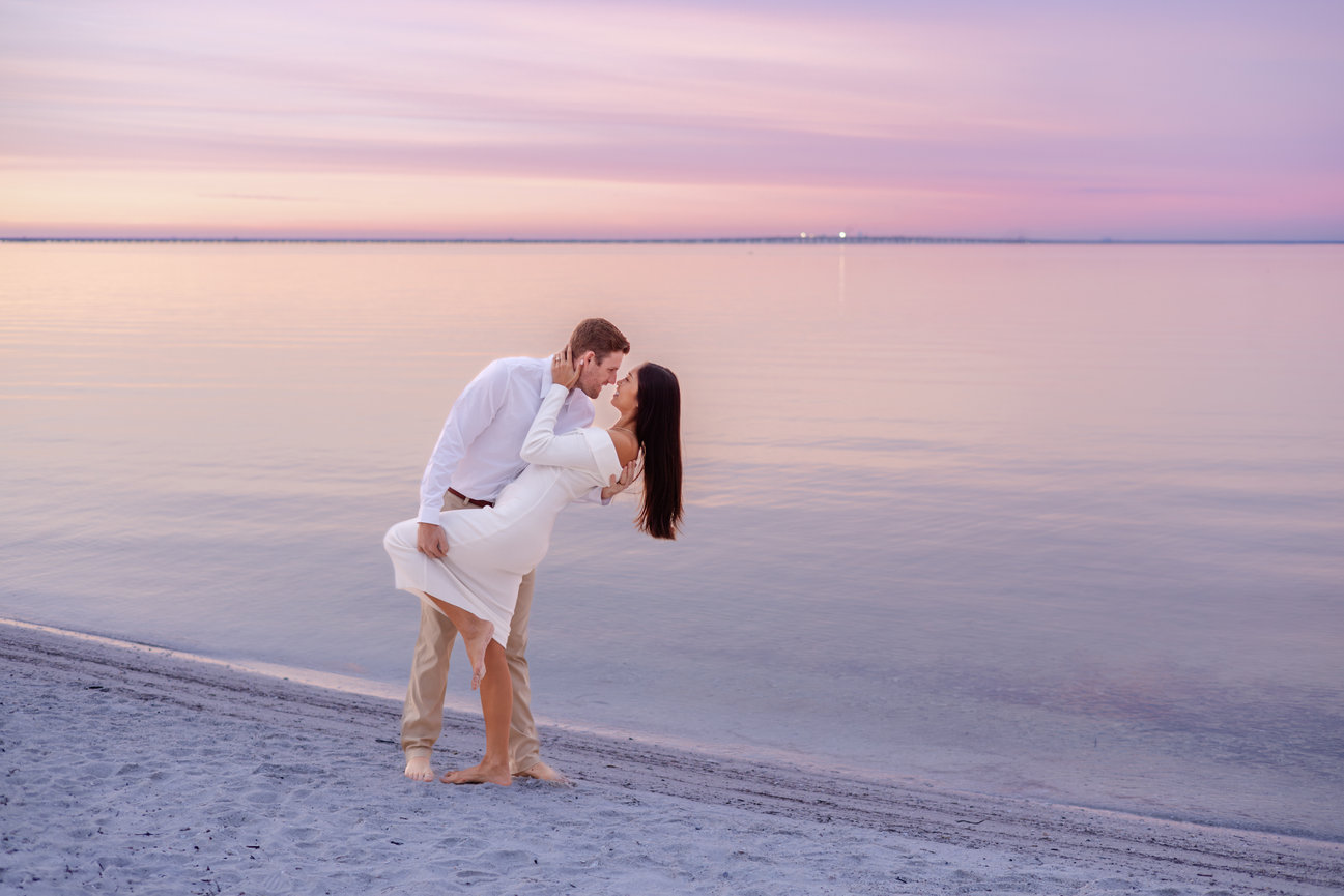 A couple in white attire on a Ben T. Davis Beach at a sunrise engagement session with Nicholl Hyatt Photography.