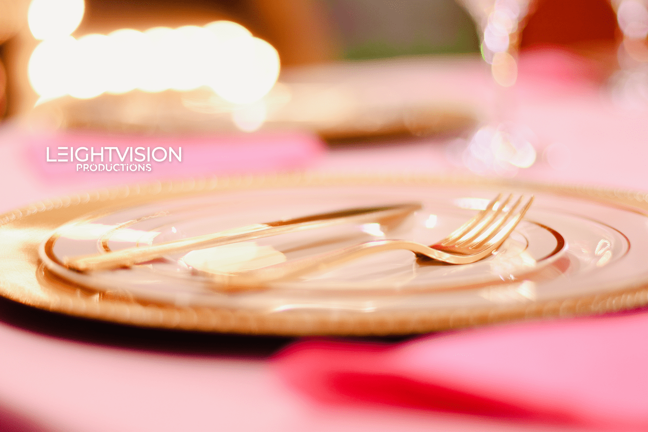 A gold plate accompanied by a fork and knife, representing a sophisticated table setting.