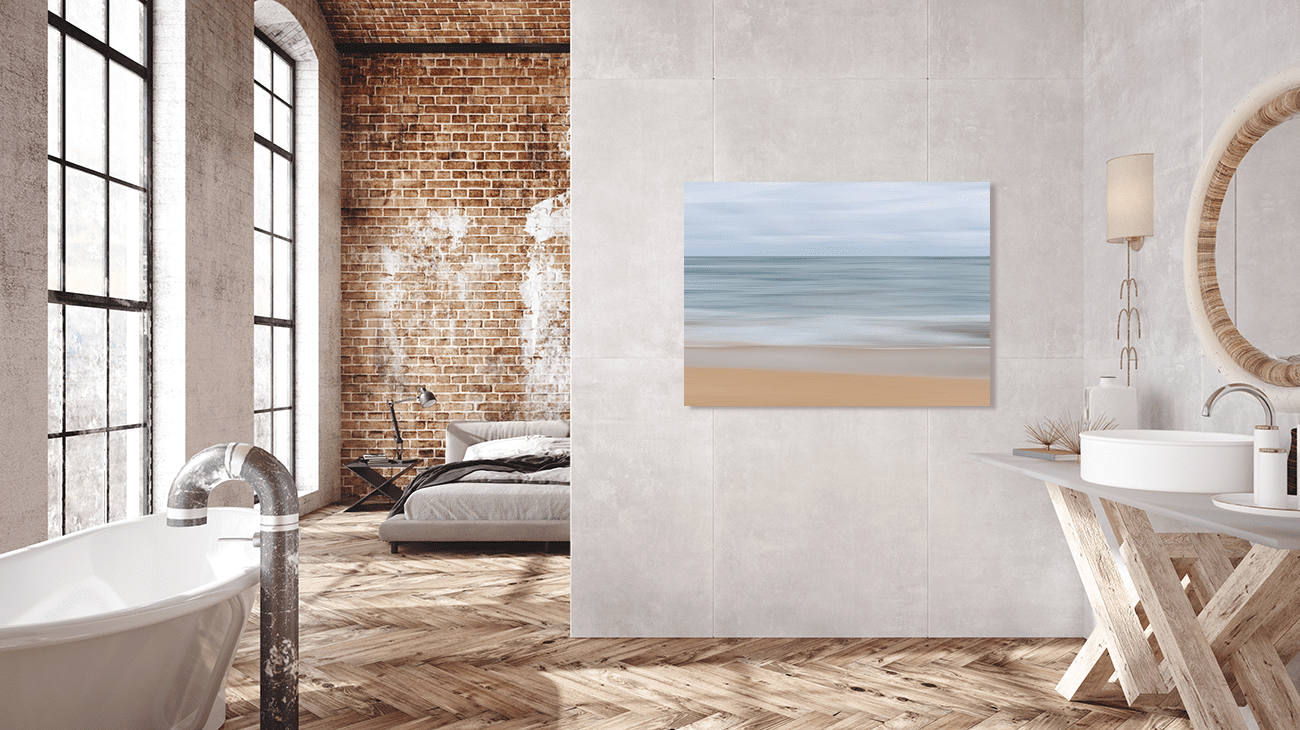 Large scale light blue and sand coloured Abstract Seascape Wall Art displayed in a modern open bathroom with concrete walls and wood floor.