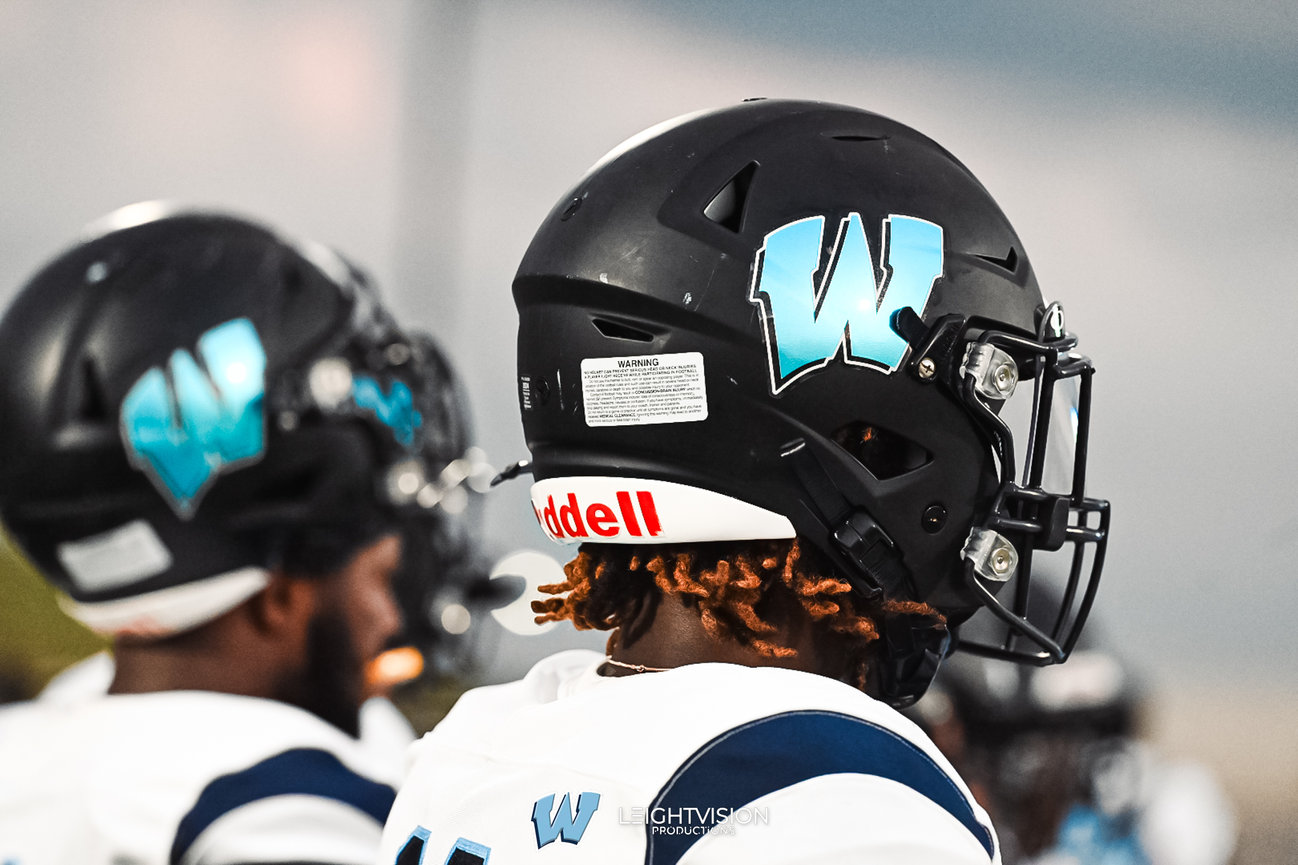 A close-up view of two football players in helmets, showcasing their focused expressions and athletic gear.