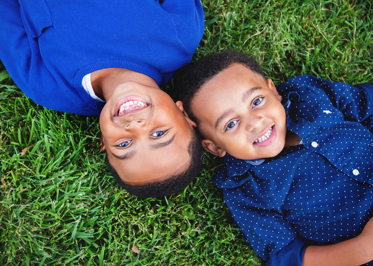 brothers in blue laying in the grass