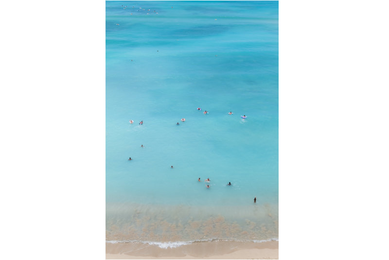 Waves of Calm by Andrea Bruns, an aerial view of swimmers drifting through expansive turquoise water at Waikiki Beach.