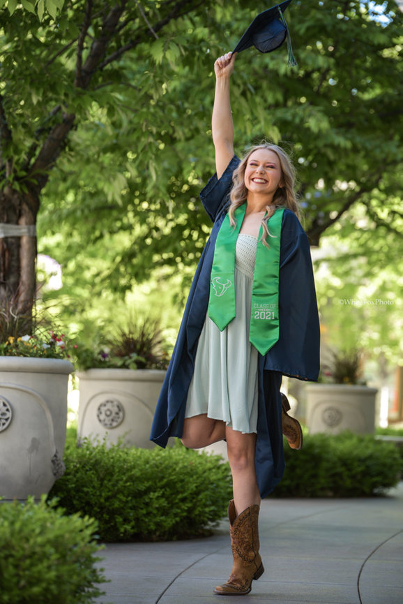 Senior year cowgirl, boots, cap and gown celebrating in Boise Idaho