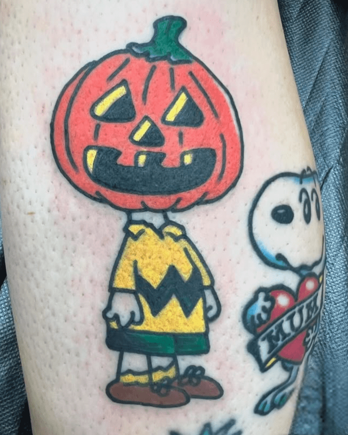 Color tattoo of the Peanuts character Charlie Brown with a pumpkin on his head.