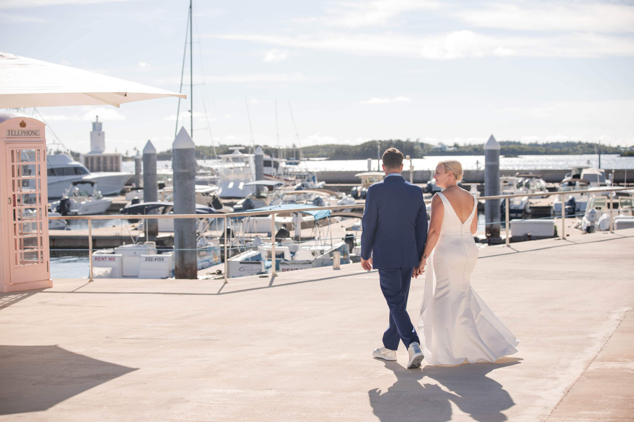 A cinematic, sunset moment on a private dock in Hamilton Harbor, showcasing the effortless sophistication of a Bermuda maritime reception and the soft glow of the horizon.
