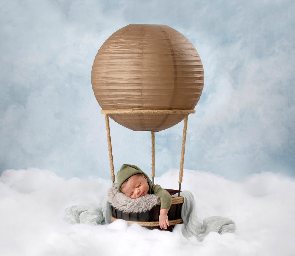 Baby sleeping in a basket with hot air balloon decor