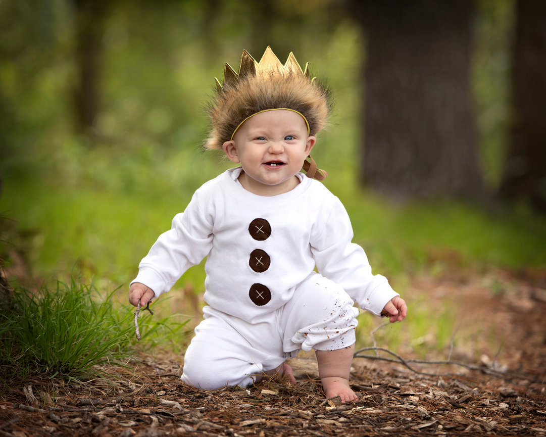 Child wearing a costume with a crown in the woods