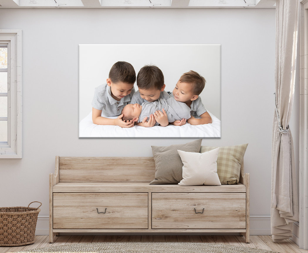 Framed photo of three children displayed above a couch in a bright living room