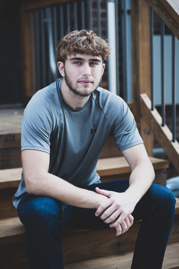 senior guy sitting on steps looking relaxed