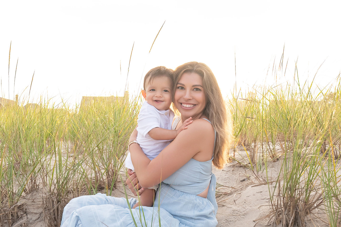 Mother holding child close during golden hour on the beach