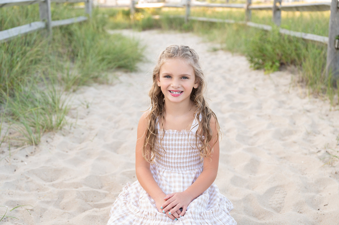 Editorial-style beach photo with wind-blown hair and soft light