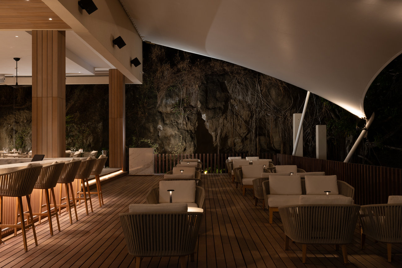 Restaurant in the Evening with Tent Ceiling and backdrop of carved out mountain on the ocean at Silversands Beach House.