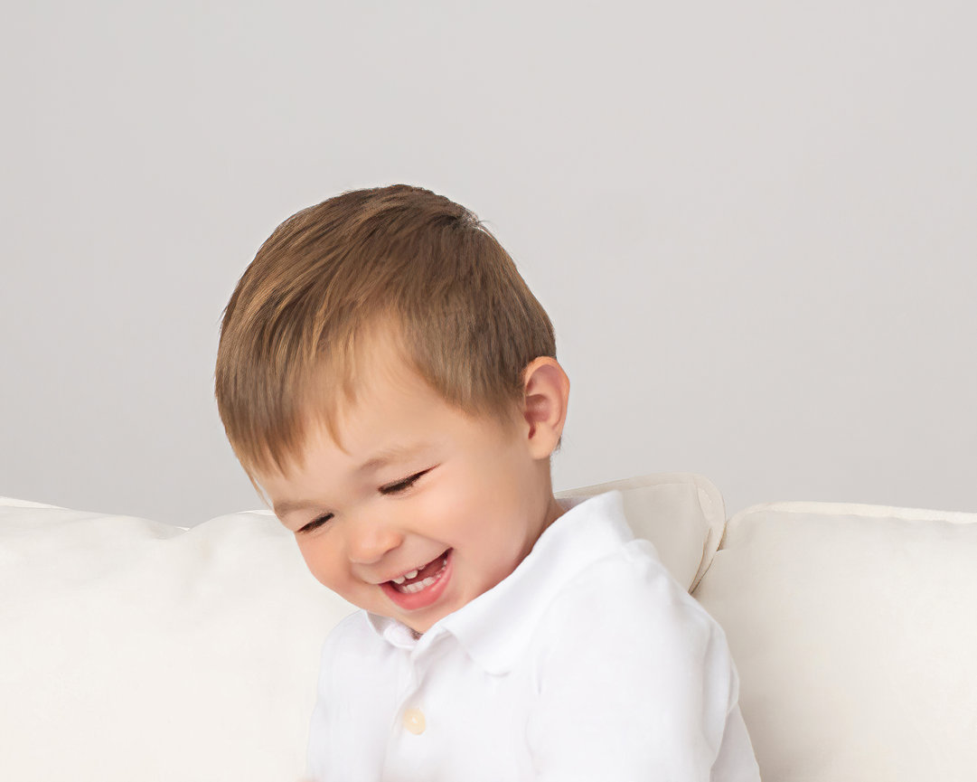 Laughing toddler captured in clean white studio space