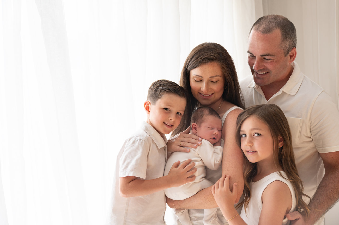 Family snuggle with white backdrop and natural light