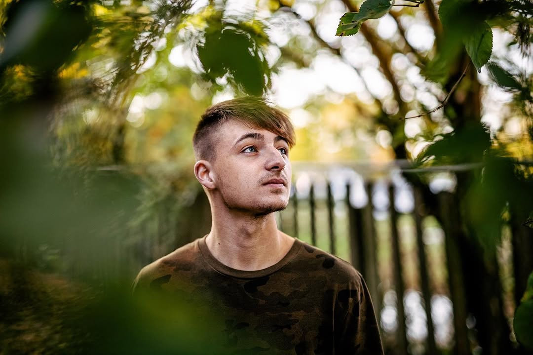Man looking through leaves in a natural setting