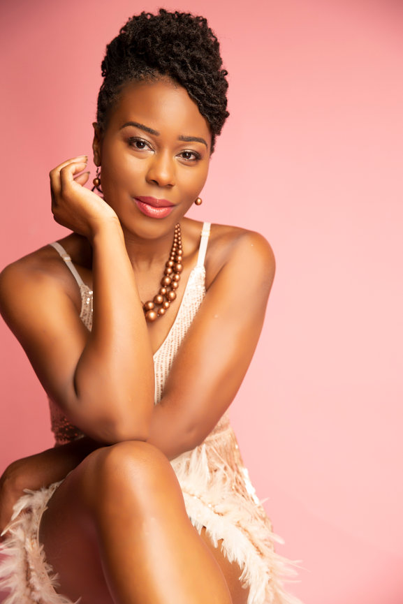 Fort Worth portrait photographer studio session with woman in elegant dress against pink backdrop.