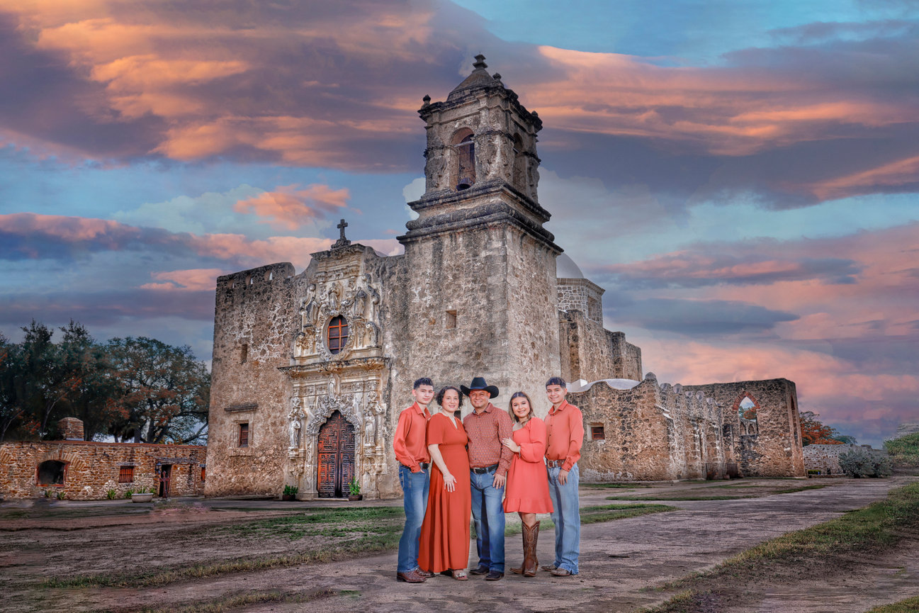 Family portrait in front of a historic church, set against a colorful sunset sky.