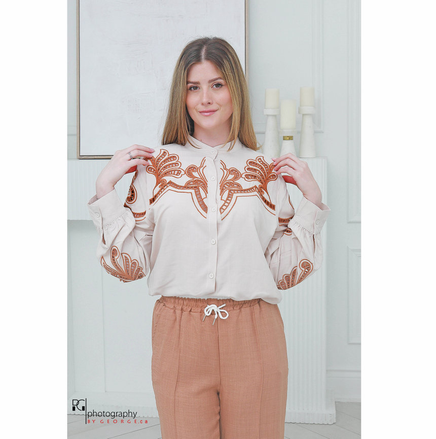 Model wearing a neutral embroidered blouse with artisan-inspired detailing for Summer 2026.