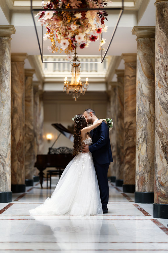 Bride and groom embracing in the elegant hall of Hôtel des Trois Couronnes in Vevey, Switzerland