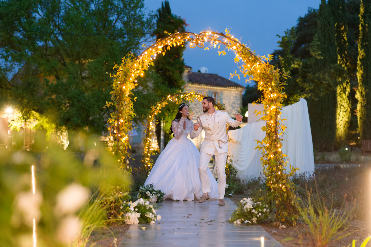Wedding couple under a floral arch in Provence, France