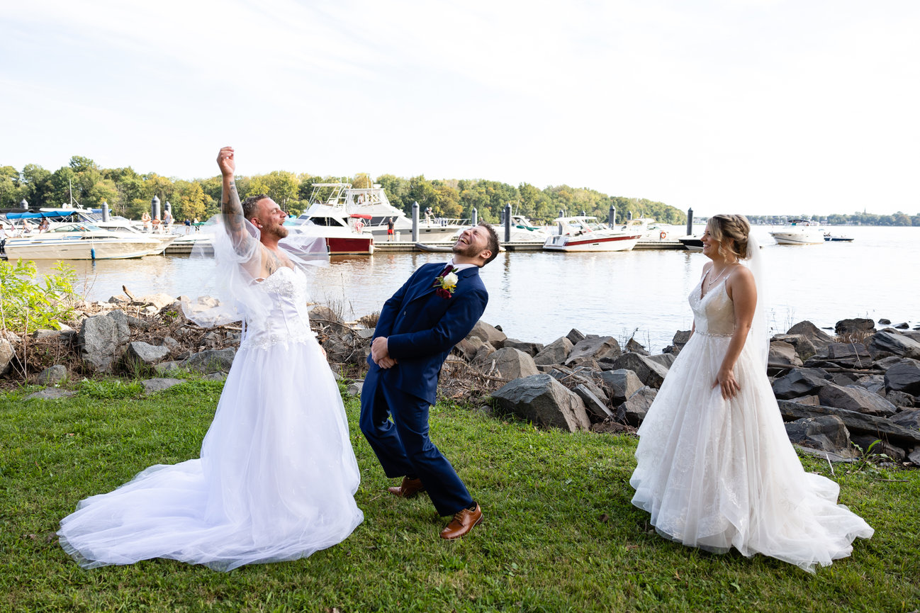 Bride and groom being playful on a waterfront lawn at a New Jersey wedding venue