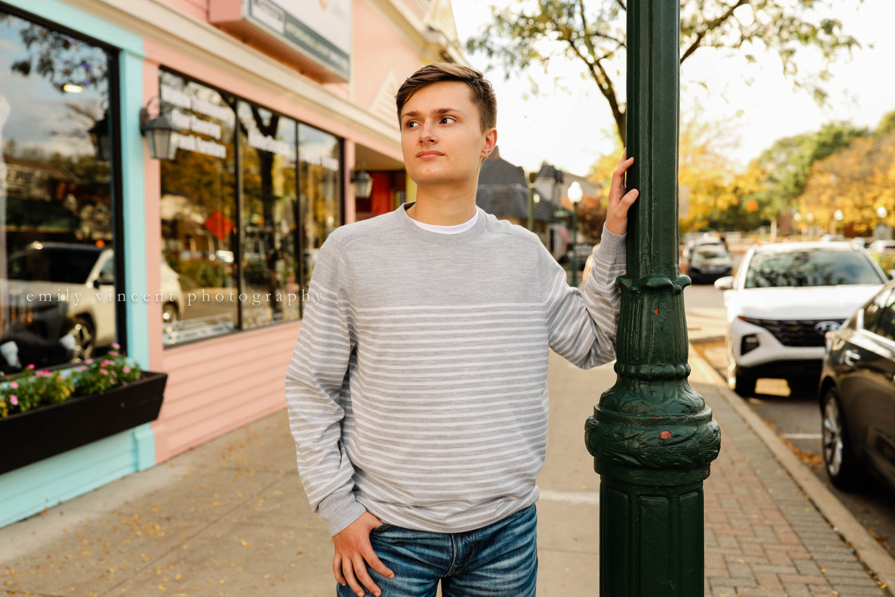Senior boy looking away thoughtfully in outdoor photo, downtown area